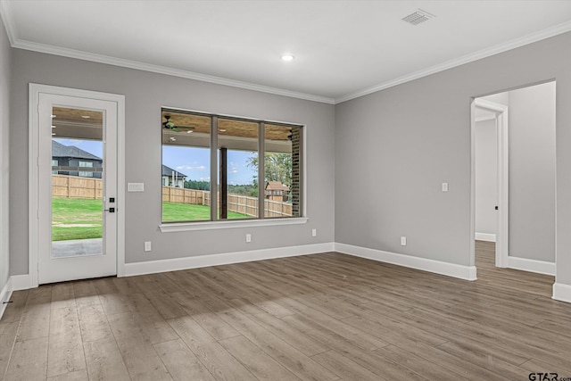 unfurnished room featuring plenty of natural light, light wood-type flooring, and crown molding