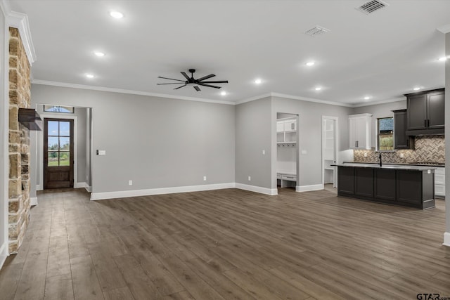 unfurnished living room with ceiling fan, crown molding, dark hardwood / wood-style floors, and sink