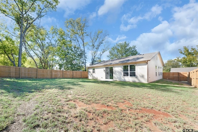 rear view of house featuring a lawn