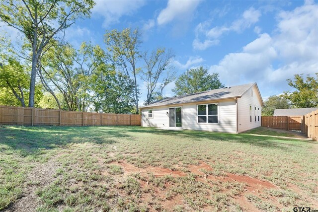 rear view of house featuring a lawn