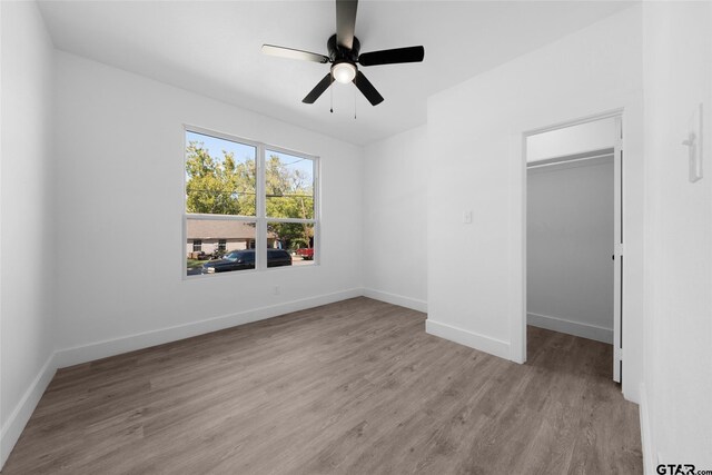 unfurnished bedroom with a closet, light hardwood / wood-style floors, and ceiling fan