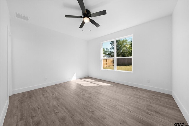 empty room featuring hardwood / wood-style flooring and ceiling fan