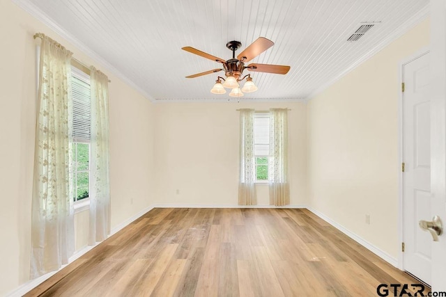 spare room featuring light wood-style floors, visible vents, crown molding, and ceiling fan