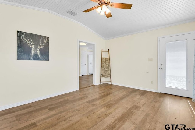 spare room with light wood finished floors, vaulted ceiling, visible vents, ceiling fan, and crown molding