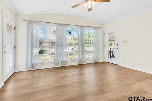 empty room featuring baseboards, lofted ceiling, wood finished floors, ceiling fan, and crown molding