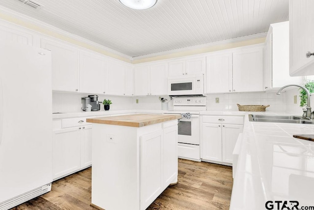 kitchen featuring white cabinets, a kitchen island, a sink, and white appliances