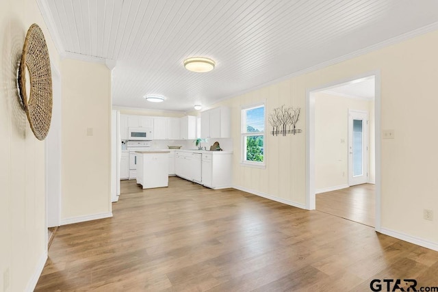 unfurnished living room featuring light wood-style flooring, baseboards, and ornamental molding