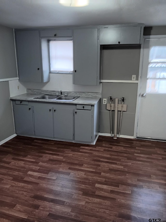 kitchen featuring dark wood-type flooring, a healthy amount of sunlight, light countertops, and a sink