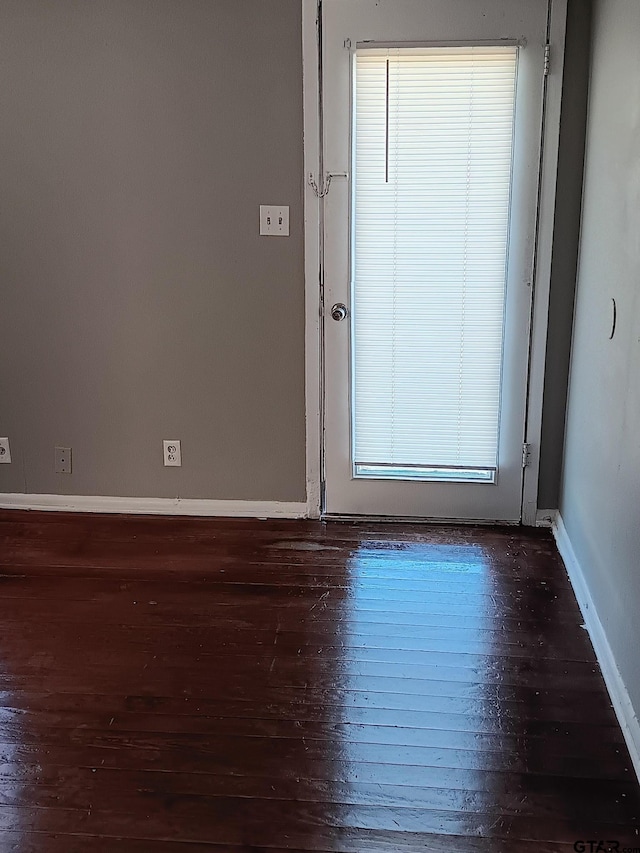 unfurnished room featuring baseboards and wood finished floors