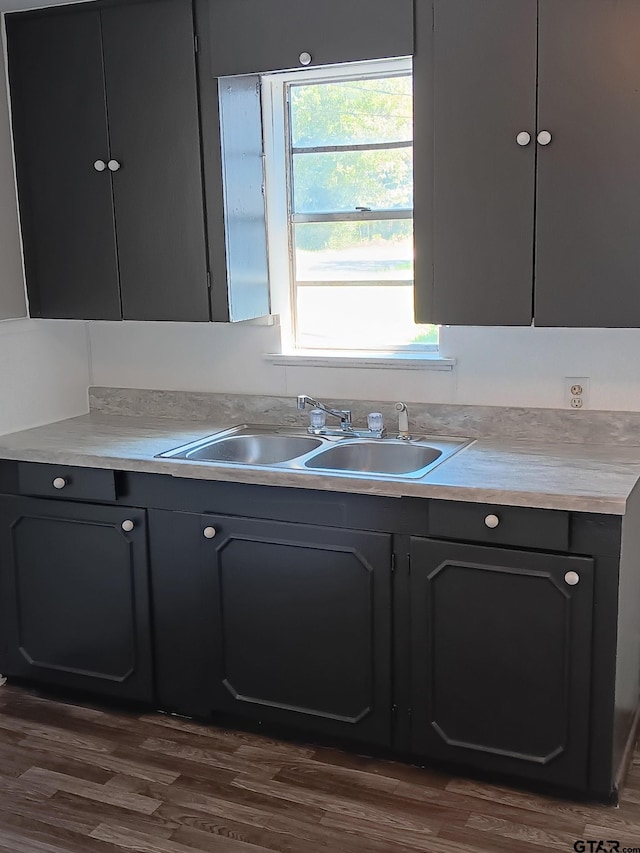 kitchen featuring a sink, dark wood-style floors, and light countertops