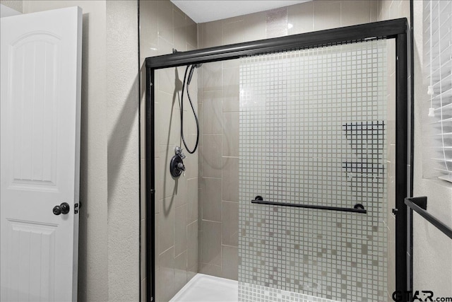 bathroom featuring a shower with door