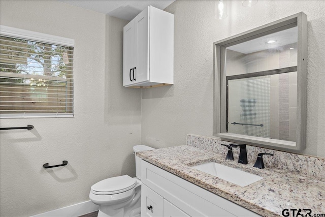 bathroom with vanity, toilet, and a shower with shower door