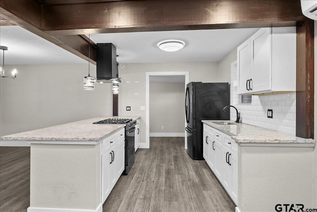 kitchen featuring sink, hardwood / wood-style floors, pendant lighting, white cabinets, and black appliances