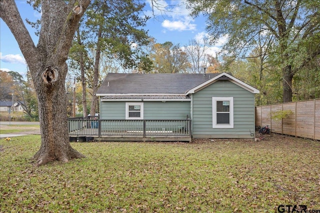 rear view of property with a deck and a lawn