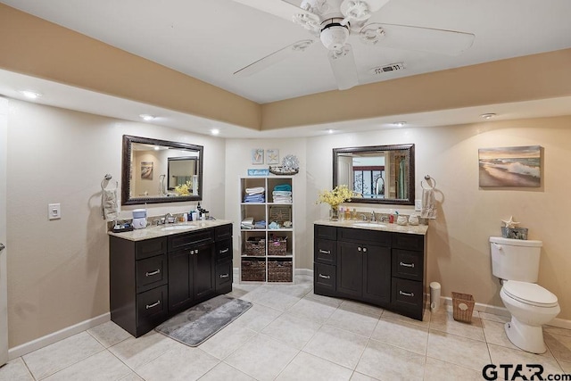 bathroom featuring visible vents, two vanities, and a sink