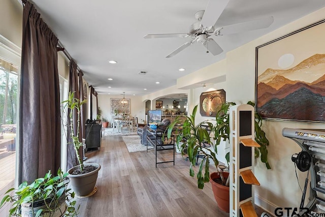 hallway with recessed lighting, arched walkways, wood finished floors, and visible vents