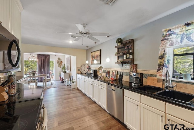 kitchen with a healthy amount of sunlight, dark countertops, stainless steel appliances, and a sink