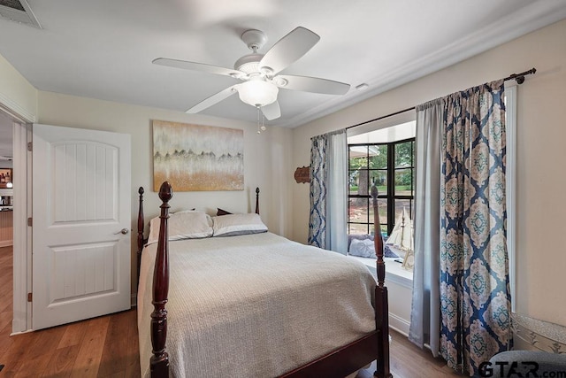 bedroom featuring ceiling fan, visible vents, and wood finished floors