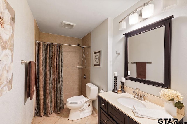 bathroom with tile patterned flooring, a tile shower, toilet, and vanity