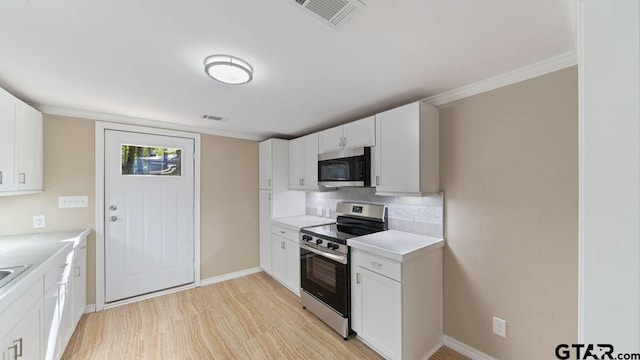 kitchen featuring decorative backsplash, white cabinetry, appliances with stainless steel finishes, and light hardwood / wood-style flooring