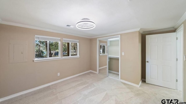 unfurnished bedroom with light colored carpet, ornamental molding, electric panel, and a closet