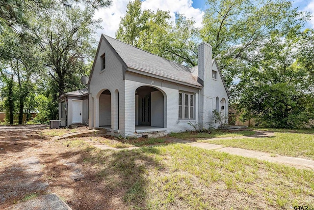 view of front of property with cooling unit and a front yard