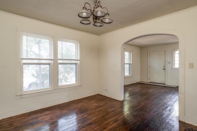 unfurnished dining area with ornamental molding, a healthy amount of sunlight, dark hardwood / wood-style floors, and a textured ceiling