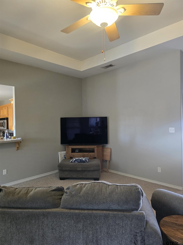 living room with ceiling fan, carpet floors, visible vents, and baseboards