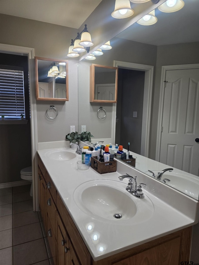 bathroom with a sink, toilet, and tile patterned floors