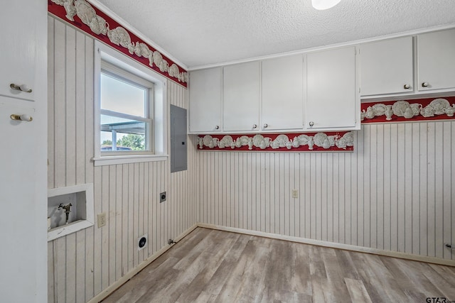 laundry room with cabinets, a textured ceiling, electric panel, hookup for an electric dryer, and light hardwood / wood-style floors