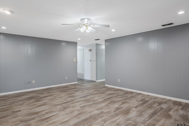 spare room featuring a textured ceiling, light hardwood / wood-style floors, and ceiling fan