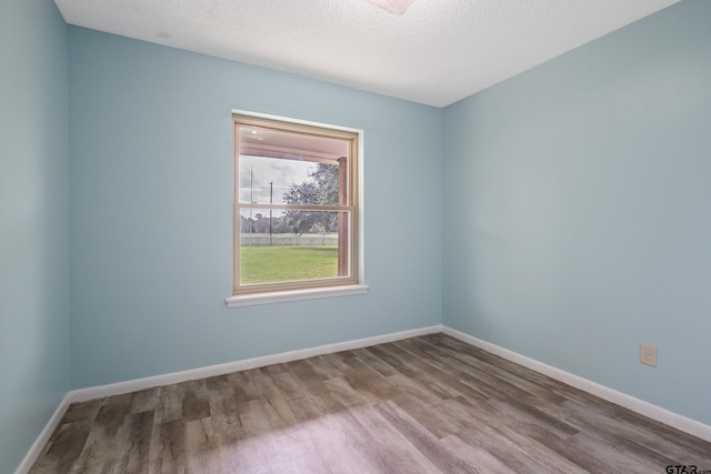 empty room featuring hardwood / wood-style flooring and a textured ceiling