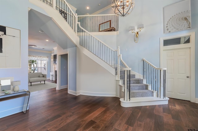 stairs with hardwood / wood-style flooring, a high ceiling, and ornamental molding