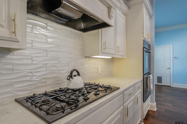 kitchen with tasteful backsplash, range hood, white cabinetry, dark hardwood / wood-style flooring, and black gas stovetop