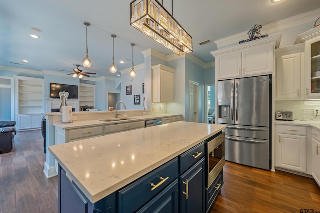 kitchen with dark wood-type flooring, a center island, blue cabinetry, pendant lighting, and appliances with stainless steel finishes