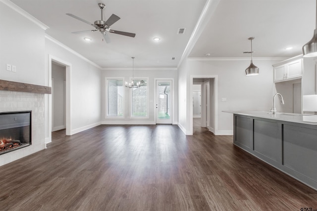 7013 Hillside Ave, Tyler, TX 75707 - unfurnished living room featuring ceiling fan, ornamental molding, baseboards, a warm lit fireplace, and dark wood-style flooring