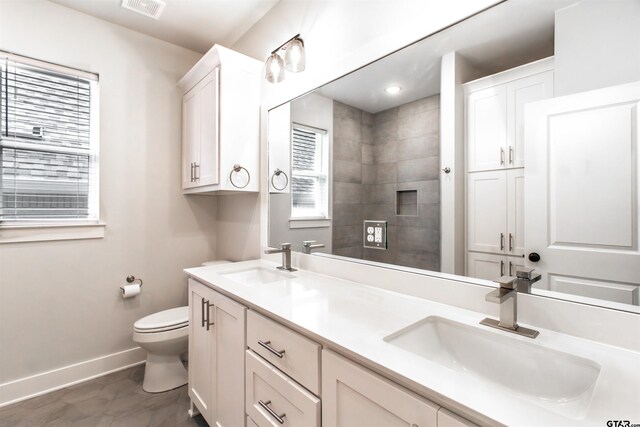 7013 Hillside Ave, Tyler, TX 75707 - full bathroom featuring baseboards, double vanity, and toilet