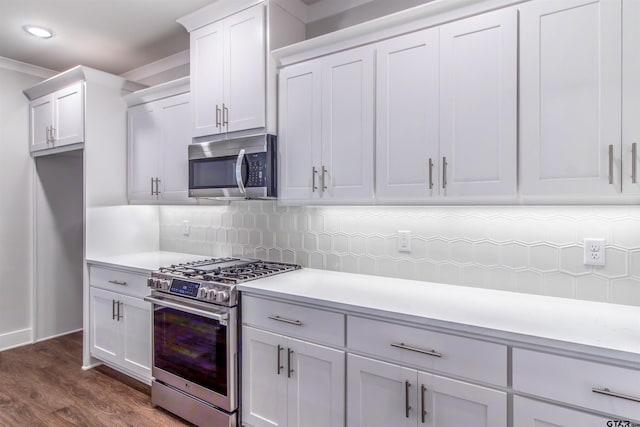 7013 Hillside Ave, Tyler, TX 75707 - kitchen featuring stainless steel appliances, light countertops, dark wood finished floors, backsplash, and recessed lighting