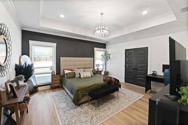 bedroom with hardwood / wood-style floors, a raised ceiling, and ornamental molding