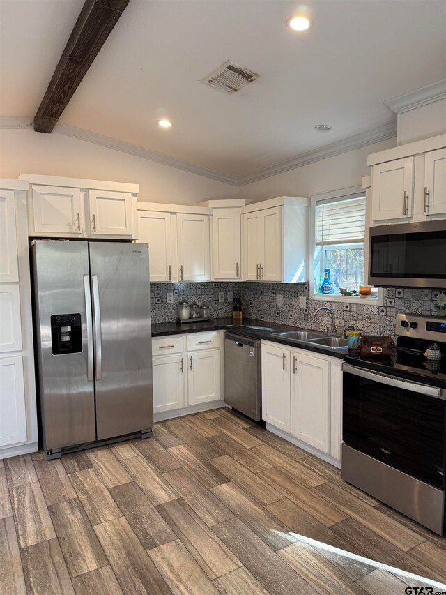 kitchen featuring sink, hardwood / wood-style floors, decorative backsplash, white cabinets, and appliances with stainless steel finishes