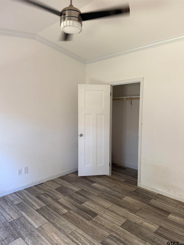 unfurnished bedroom featuring crown molding, a closet, and dark wood-type flooring