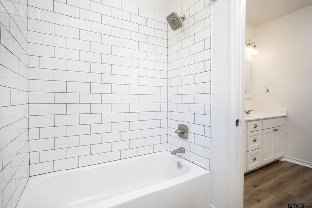 bathroom with vanity, hardwood / wood-style flooring, and tiled shower / bath