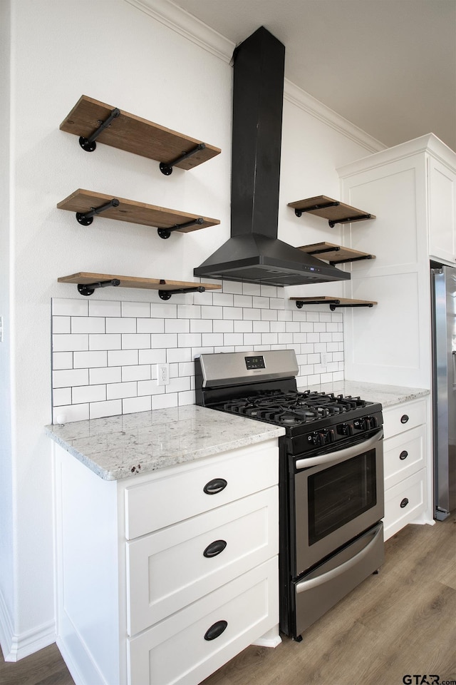 kitchen with island range hood, ornamental molding, stainless steel appliances, and white cabinets