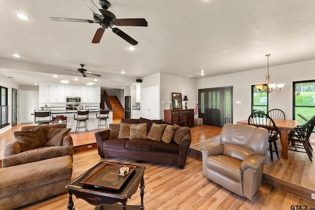7016 Fm 3054, Malakoff, TX 75148 - living room featuring light wood-style flooring, ceiling fan, recessed lighting, stairway, and a chandelier