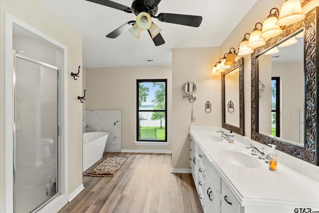 7016 Fm 3054, Malakoff, TX 75148 - full bathroom with wood finished floors, a freestanding tub, a shower stall, double vanity, and baseboards