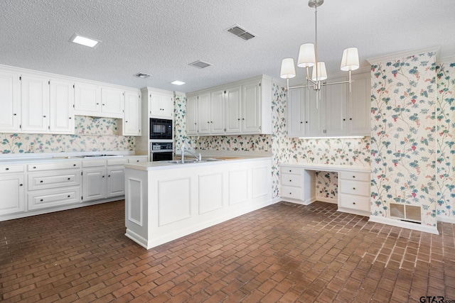 kitchen featuring white cabinetry, sink, decorative light fixtures, black appliances, and ornamental molding