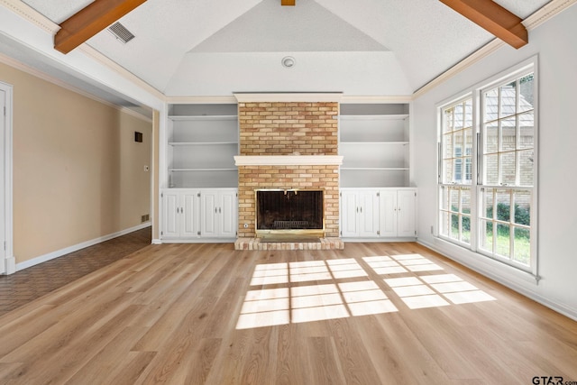 unfurnished living room featuring vaulted ceiling with beams, light hardwood / wood-style floors, a brick fireplace, and a wealth of natural light