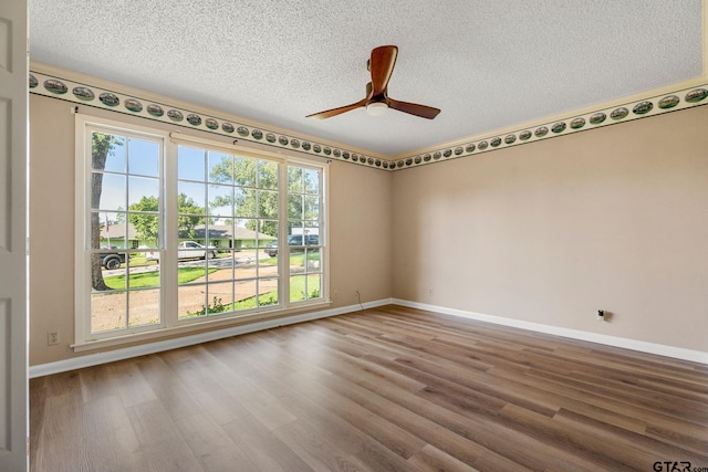 spare room featuring a textured ceiling, hardwood / wood-style flooring, plenty of natural light, and ceiling fan