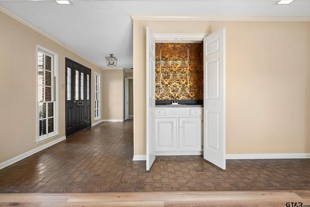 entrance foyer featuring sink and crown molding