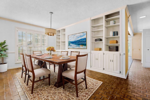 dining space with built in shelves, a textured ceiling, and ornamental molding